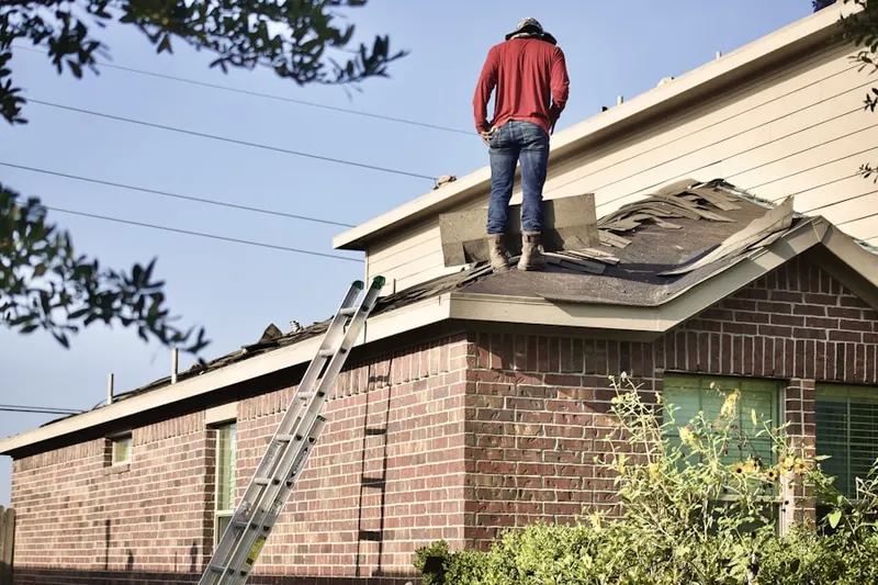 Professional roofer working on a residential roof in Fenton